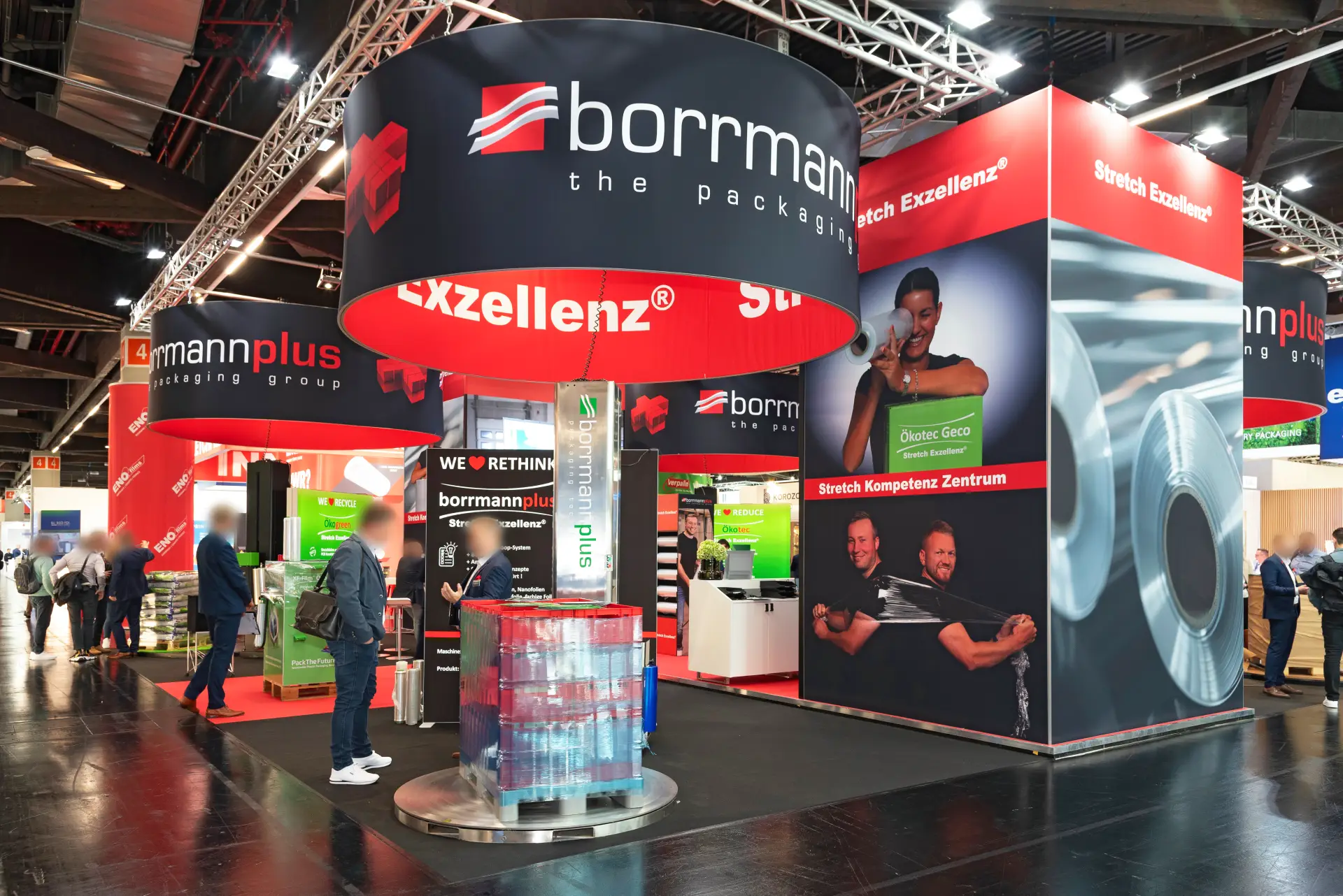 Moderner Messestand von borrmannplus auf der FachPack Messe in Nürnberg mit stilvollem Design, Stretchfolie-Displays und roten Akzenten – professioneller Messebau Nürnberg.