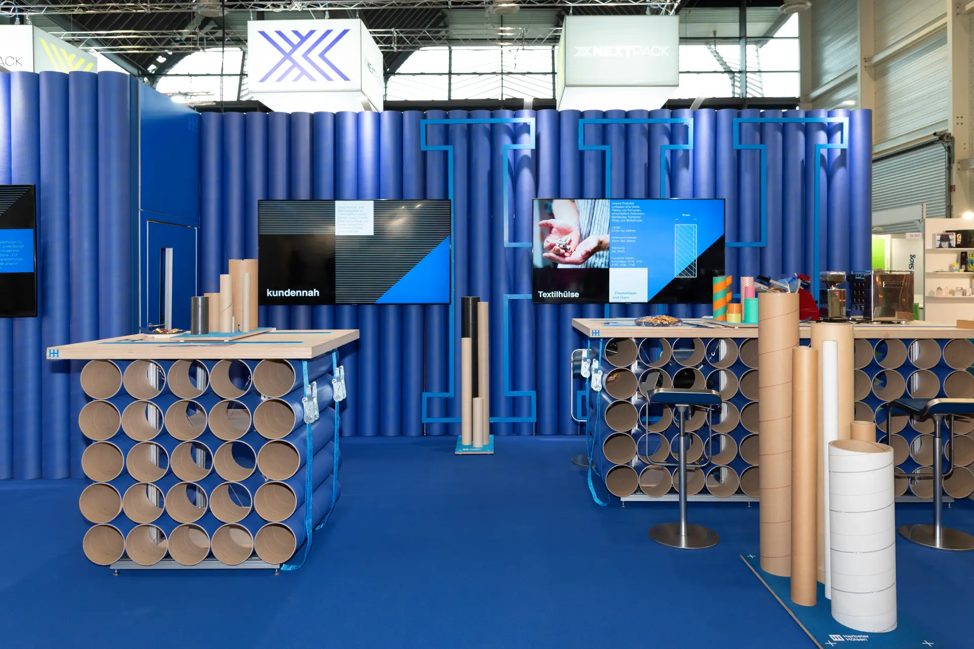FachPack 2025 Messestand von Herbster Hülsen mit modernem blauen Design, Präsentation nachhaltiger Hülsenprodukte und Recyclinglösungen – Messebau Nürnberg.