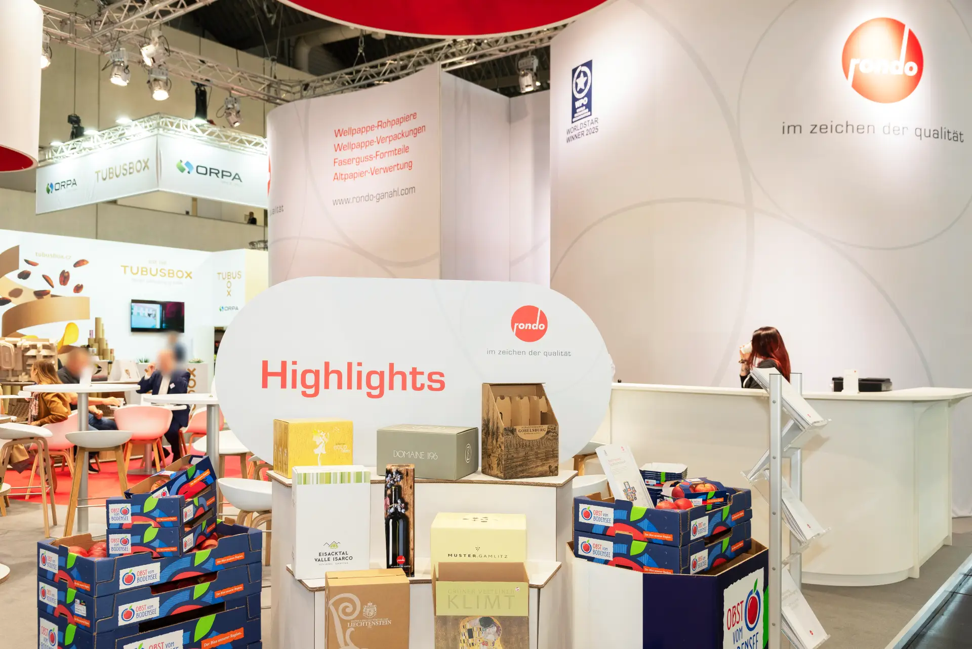 Gesamtansicht des Rondo Ganahl Messestands auf der FachPack 2025 mit rotem Design und nachhaltigen Verpackungslösungen – Messebau Nürnberg.
