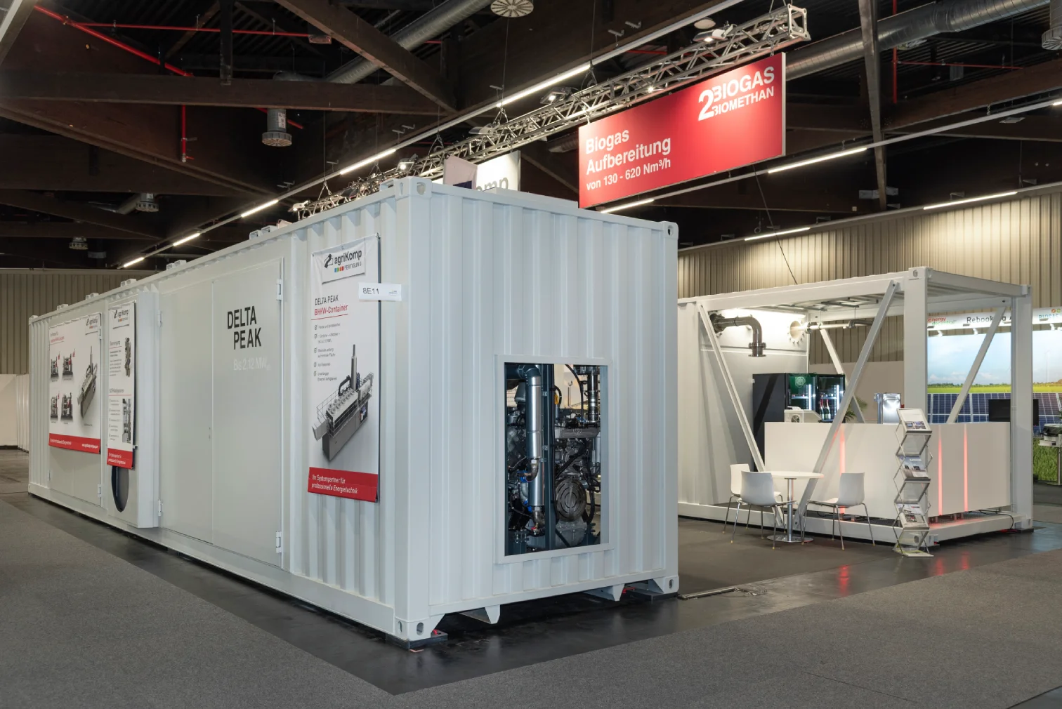 Weisser Container-Messestand von agriKomp mit roten Lichtakzenten und Truss-Beschilderung in einer Messehalle in Nuernberg.