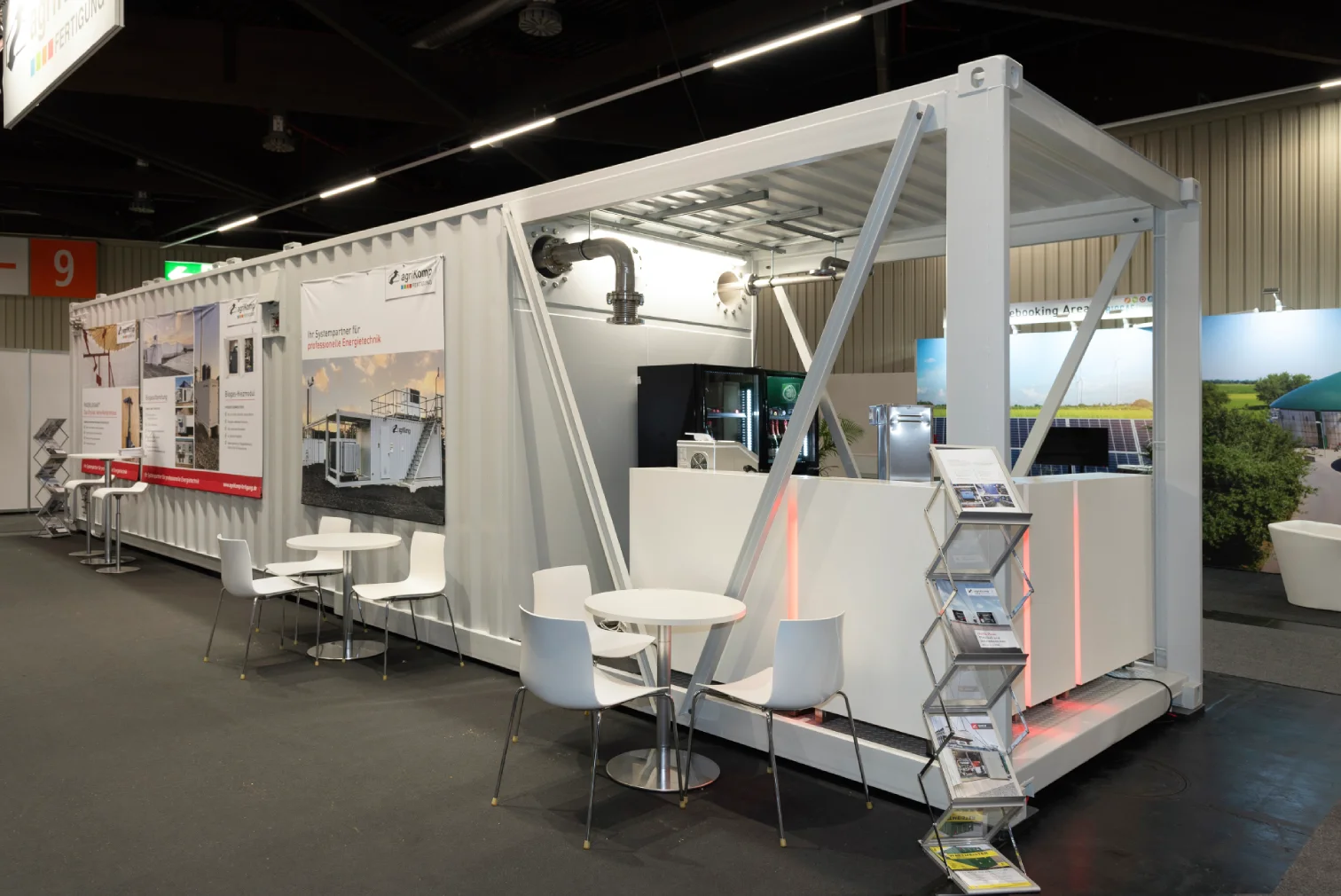Messestand von agriKomp aus weissem Container mit Banner Ihr Systempartner fuer professionelle Energietechnik, Bistrotischen und Prospektstaender in Halle 9 Nuernberg.