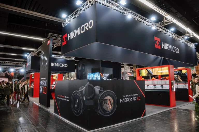 Schwarzer HIKMICRO Messestand mit beleuchtetem Traversen-Dach und Produktdisplay des Wärmebildgeräts HABROK 4K 2.0, Messebau in Dortmund.