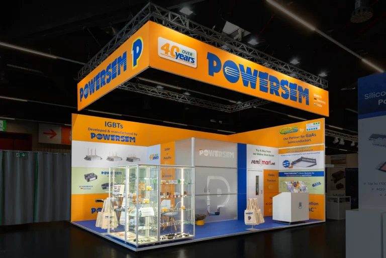 Messebau-Stand der Powersem GmbH auf der PCIM Nuernberg in Orange und Blau mit Jubilaeums-Banner 40 years und beleuchteten Vitrinen.