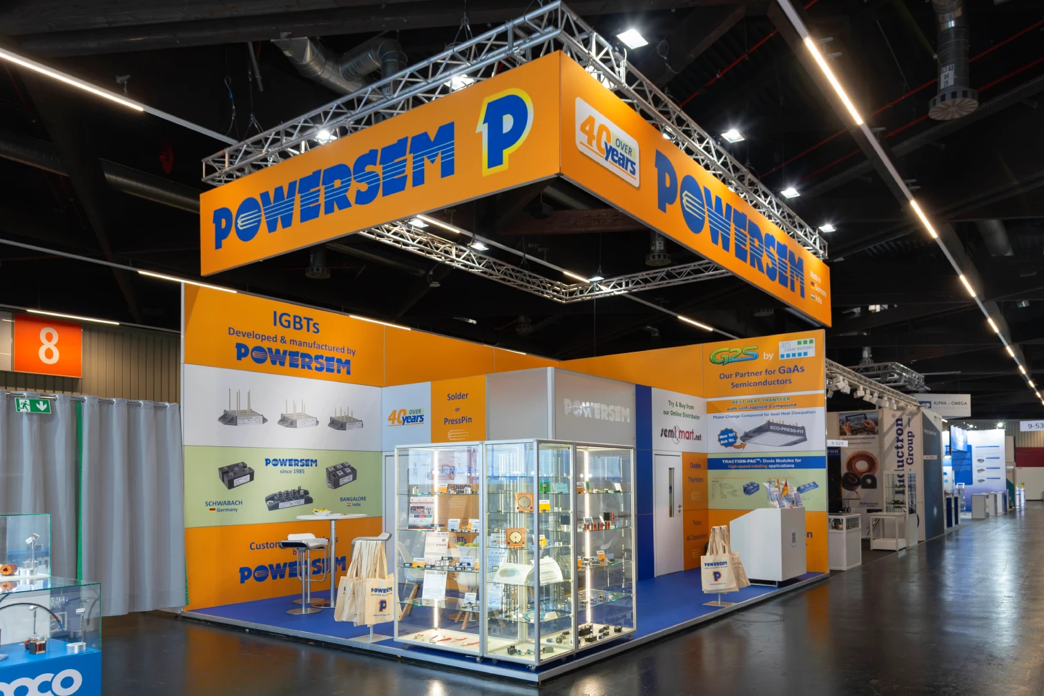 Freistehender Powersem-Messestand auf der PCIM in Nürnberg mit umlaufendem Traversen-Banner POWERSEM, Glasvitrine, IGBTs-Werbewand und Hallengang mit Standnummer 8.